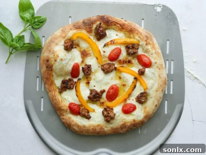 baked italian sausage pizza on pizza peel
